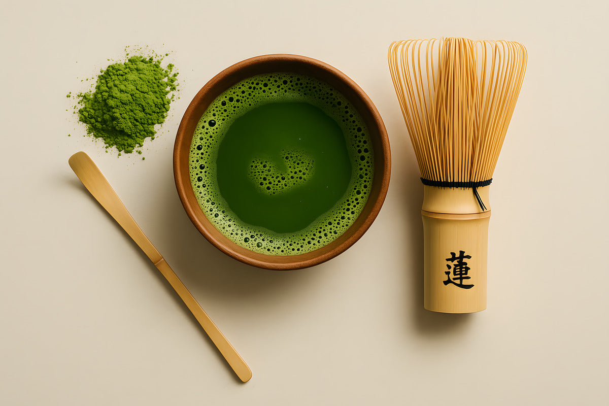 Top-down view of a traditional Japanese matcha tea setup with a bowl of vibrant green matcha, a bamboo whisk, and matcha powder on a neutral background